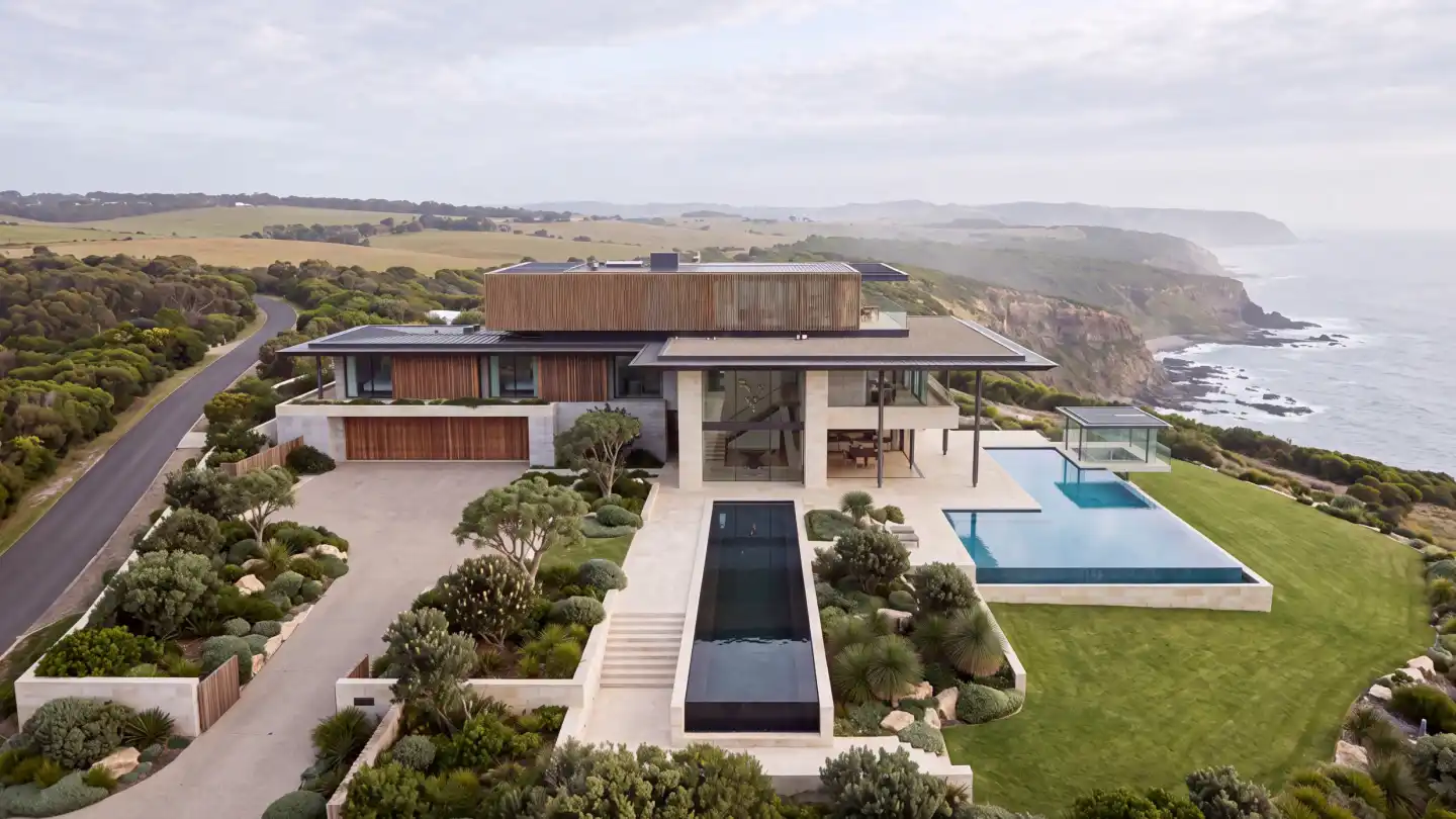 The finished estate at midday: limestone and timber pavilions, reflection pond, infinity pool at the cliff edge.